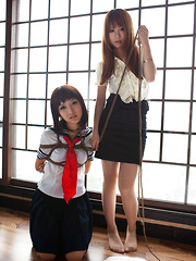 Dimdim Asian in uniform is tied in ropes by another sexy cupcake